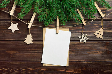 Christmas greeting card mockup with festive decorations and fir tree branches on dark wooden background