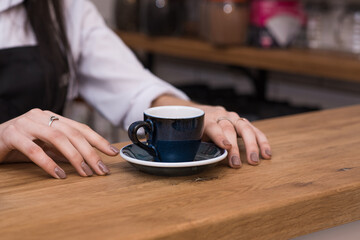 Barista girl gives delicious, aromatic and invigorating espresso coffee