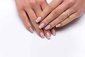 New Year's white French manicure on long square nails with snowflakes, crystals, rolls, close-up on a white background.