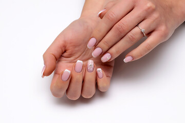 New Year's white French manicure on long square nails with snowflakes, crystals, rolls, close-up on a white background.