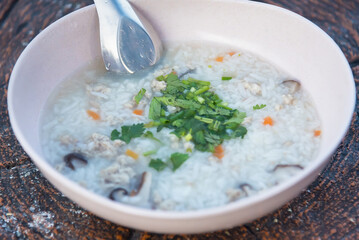 Boiled rice with pork in white bowl on table in morning.