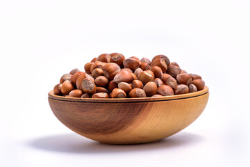 Fototapeta na wymiar Hazelnuts in a wooden bowl on white background. Solid ripe Hazelnuts side view