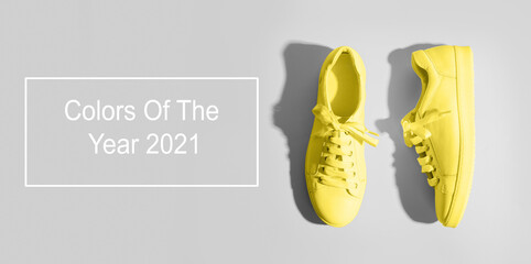 Banner with yellow female gumshoes on grey background. View from above. Space for text. Trendy color Ultimate Grey and Illuminating of the 2021 year. Space for text.