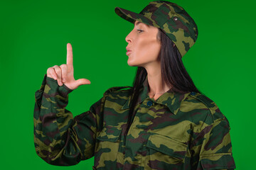 Profile photo. Portrait of a woman in military uniform, hand imitating weapon on green. Breaking...