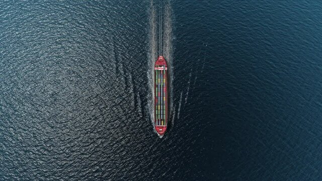Cargo ship with containers sailing in the open blue sea- Top down view 
, Freight Shipping export and import concept, container ship carries cargo across the ocean. Transportation. Delivery. Logistics