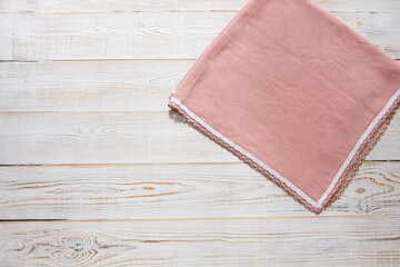 Pink napkin on white wooden table top view - close up