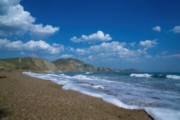 Beautiful sea panorama. The mountains descend into the sea. Blue sky with clouds and turquoise water. Black Sea