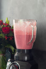 Preparing a fruit smoothie or pink milk shake in a mixer