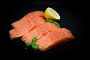 Pieces of Fresh Salmon fillet isolated on black. Red Fish on dark background 