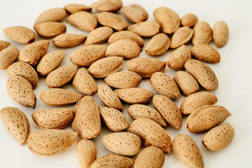 Crude almonds in a shell on a white background.