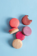 multicolored macarons on a blue background. French cuisine, copy space