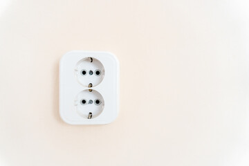 Double socket, new electric plug on white wall.