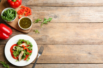 Delicious fresh chicken salad served on wooden table, flat lay. Space for text