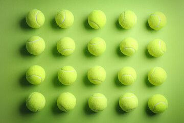 Tennis balls on green background, flat lay. Sports equipment