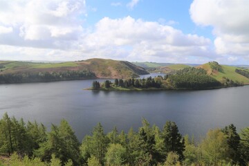 Fototapeta na wymiar A panoramic view across the tree lined foreshore of Llyn Clywedog in Powys, Wales.