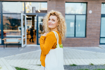 Zero waste concept with copy space. Woman holding cotton shopper and reusable mesh shopping bags with vegetables, products. Eco friendly mesh shopper. Zero waste, plastic free concept