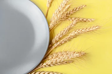 Weizen- und Roggenähren, Plattentonung in Ultimate Grey und Illuminating Color. Trockene Getreideährchen auf gelbem Hintergrund. Trendiges kreatives Design in Farbe von 2021. Nahaufnahme, flache Lage, Draufsicht, Kopierraum © lara-sh