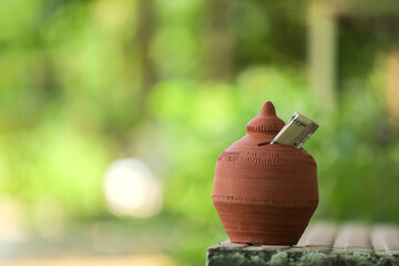 Indian rupees symbol and clay piggy bank