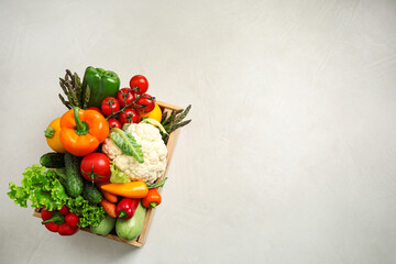 Wooden crate with fresh vegetables on white background, top view. Space for text