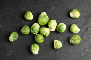 Fresh Brussels sprouts on black slate table, flat lay