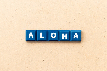 Tile letter in word aloha on wood background © bankrx