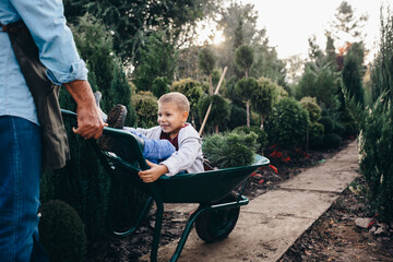 boy with his grandfather in family garden nursery