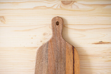 Wooden cutting board on a wooden background, space for text.