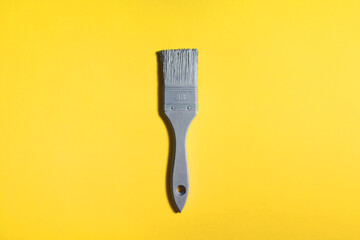 Grey brush on yellow background, trend and mod colors of 2021 year. Minimalistic vibrant picture...