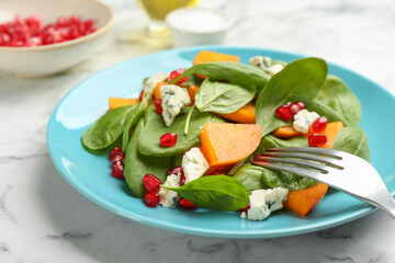 Delicious persimmon salad served on white marble table, closeup