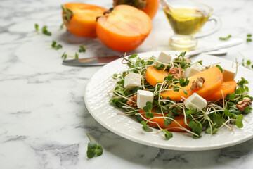 Delicious persimmon salad served on white marble table, closeup