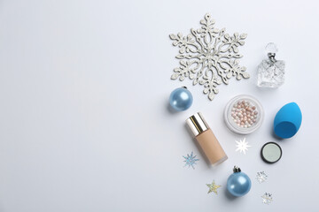Flat lay composition with decorative cosmetic products on light background. Winter care. Space for text