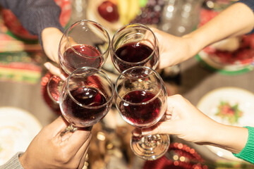 Friends with wine glasses in the restaurant for christmas. Cheers! Hands holding wine glass. Celebration, christmas and drink concept.