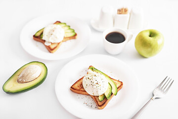 Toast with poached eggs and avocado. Healthy breakfast and food. Cozy morning. Nutrition for pregnant. Diet for women. Breakfast in hotel room or bed. Scrambled eggs sandwich.