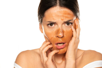 Young disappointed woman with wrong makeup base on her face