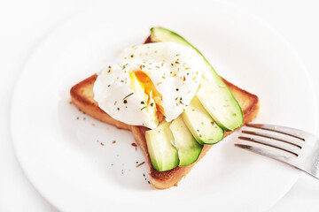 Toast with poached eggs and avocado. Healthy breakfast and food. Cozy morning. Nutrition for pregnant. Diet for women. Breakfast in hotel room or bed. Scrambled eggs sandwich.