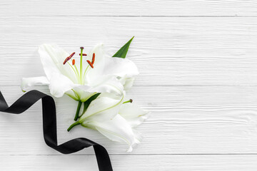 Funeral symbols - white lily flowers with black ribbon