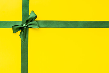 Green ribbon with bow for holiday gift box or greeting card banner. Top view