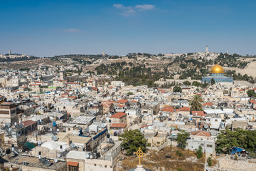 Fototapeta na wymiar Aerial view of rooftops of the old city of Islamic quarter with blue sky of Jerusalem, with Golden Dome of Rock and Mount of Olives, View from the Lutheran Church of the Redeemer.