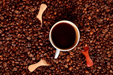 Coffee beans background with small wooden spoons