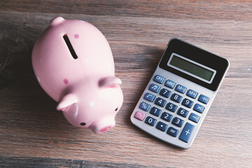 piggy bank standing near a calculator