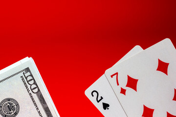 Bad combination of playing cards and money on a red background. Texas Hold'em