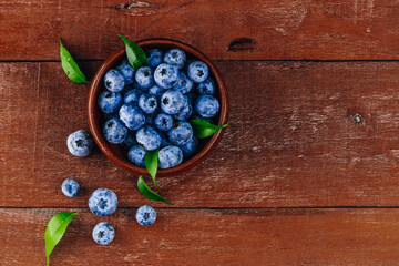  Blueberries in a bowl on a wooden background top view free space for text