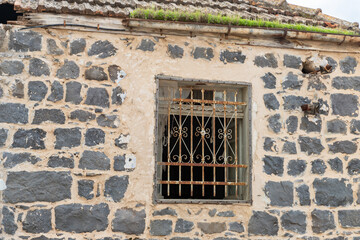 Decorative metal  lattice on the window of an abandoned house in the Muslim Circassian - Adyghe village Kfar Kama, located near the Nazareth in the Galilee, in northern Israel