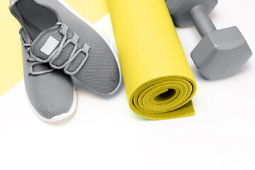 sports on a yellow background, Mat and gray sneakers. . 