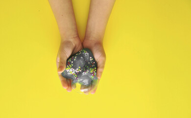 Child hands with slime on colorful background.