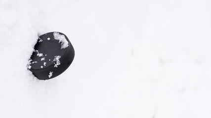 hockey puck lies on the snow macro