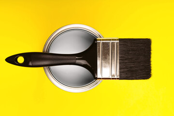 Demonstrating colors of year 2021 - Gray and Yellow. Brush with wooden handle on open can. Renovation concept. - 398474916