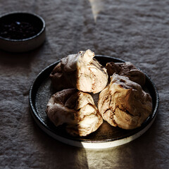 Homemade sweet chocolate meringue cookies on plate over greige linen tablecloth. Delicious and light holiday dessert
