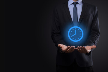 Businessman hand holds the icon of hours clock with arrow. Rapid execution of the work.Business time management and business time is money concepts