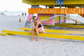 Holiday at Miami Beach Florida. Young woman near a lifeguard tower on the beach in Miami.